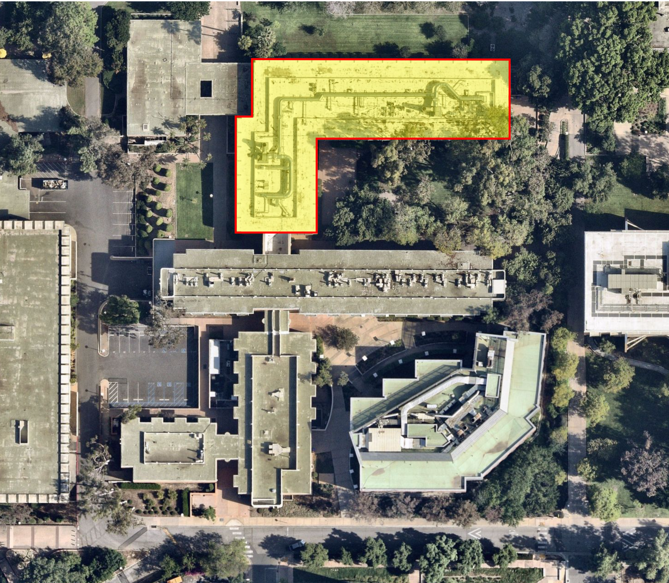An aerial view of a building complex, with the L-shaped north section of Spieth Hall highlighted in semi-transparent yellow with an orange outline.